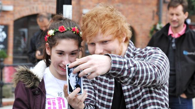 Ed Sheeran ochotně podepisoval fanynce tričko, ta měla na krytu mobilu Nialla Horana